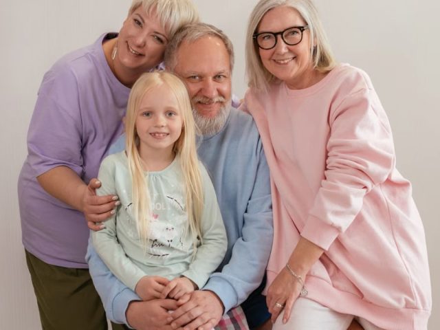 A happy multigenerational family posing indoors with smiles and affection.